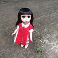 An adorable vintage doll is standing alone in a lonely place